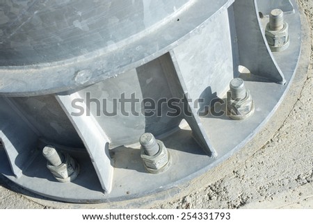 Close up of some larger screws into the base of a metal pillar.