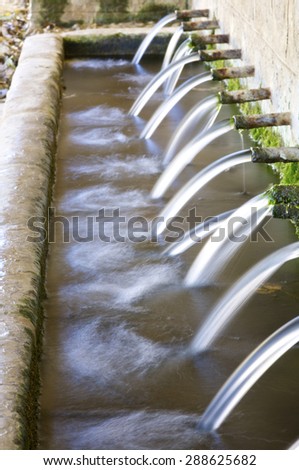 Jets of water coming through the pipes of an old fountain, Pnarroya de Tastavins, Teruel, Aragon, Spain.