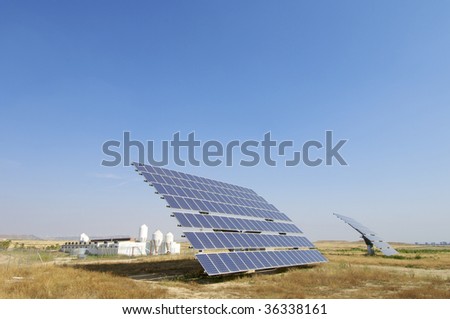 Solar field with blue sky and farm
