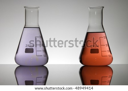 two flasks containing liquid purple and red on a white background