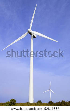 two windmills with blue and cloudy sky