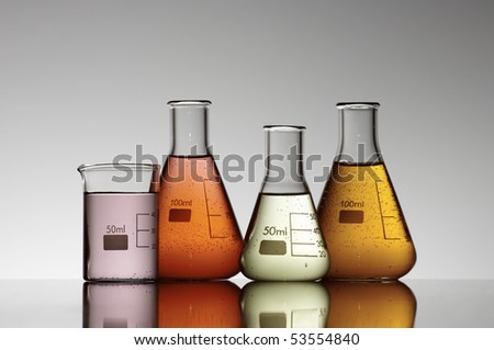 group of four flasks containing brightly colored liquid