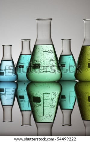 group of conical flasks containing liquid in shades of green