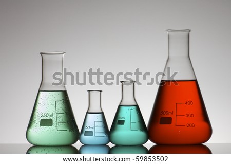 four conical glass flasks in a chemistry lab