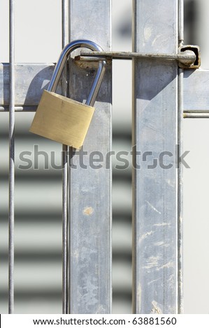 closed padlock on the door of a metal gate