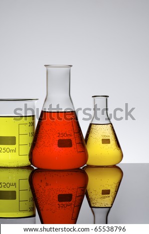 three chemical beakers with colored liquid and a white background