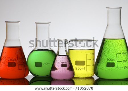 forefront of a laboratory flasks filled with colored liquid