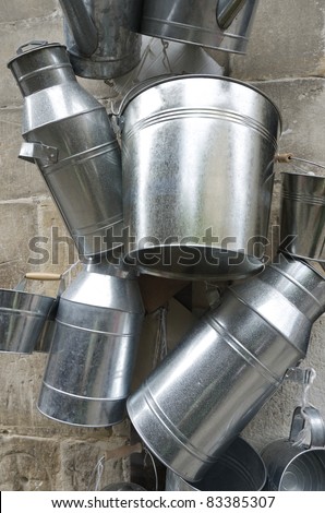 metal  containers for milk hanging from a wall