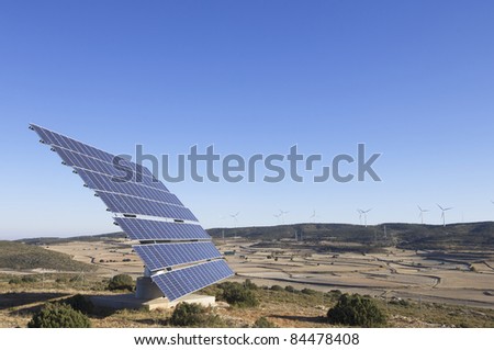 photovoltaic panels and windmills in a hill