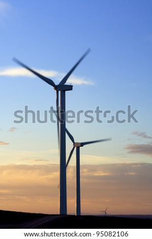view  at dusk of two windmills for renewable electric energy production