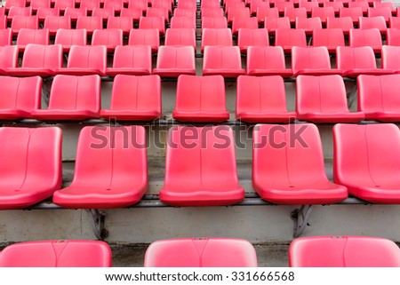 Empty red seats in football stadium.