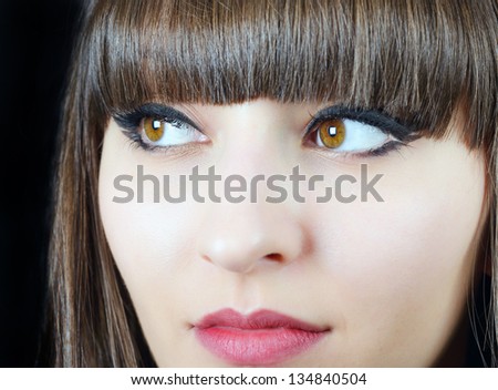 Portrait of a young beautiful woman with bangs in studio