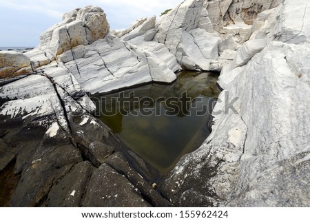 Rock pool with rushing water and seaweed