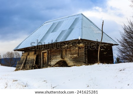 Old wooden barn in the countryside, modern roof in winter