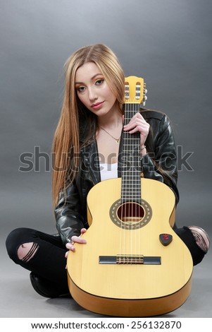a beautiful young blonde with a classical guitar
