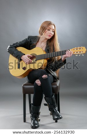 a beautiful young blonde with a classical guitar