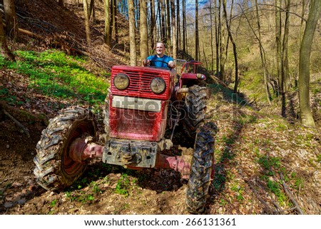farmer driving a old tractor in forest