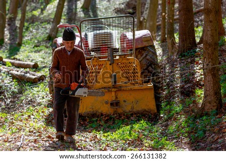 old man with a chainsaw in the forest