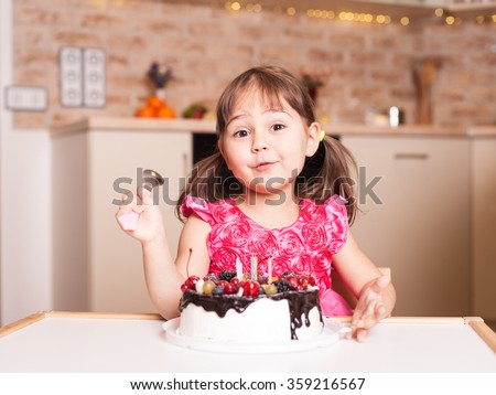 surprised little girl with cake and spoon