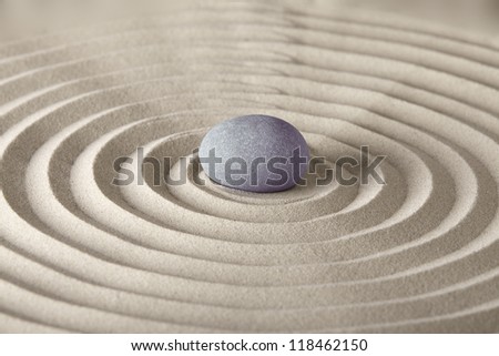 spirituality and purity stone in sand circles spa background in zen garden concept for relaxation concentration and meditation