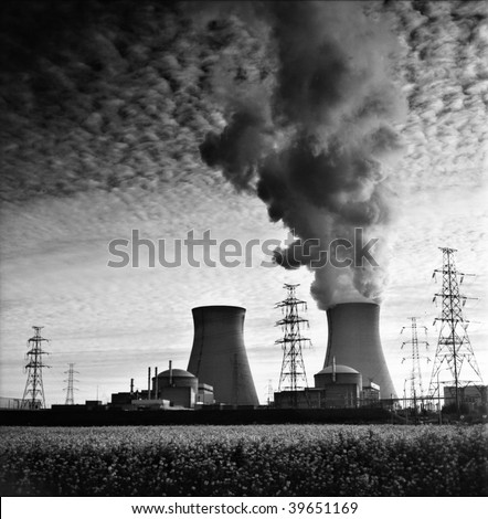 cooling towers of a nuclear power plant creating dark clouds monochrome film grain