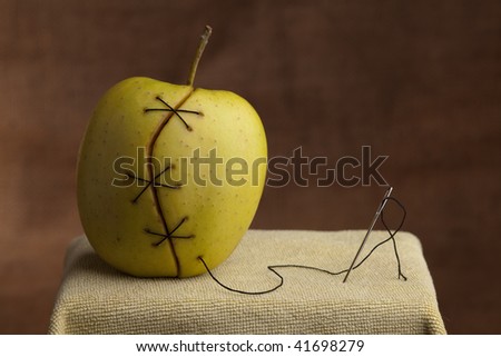 apple manipulated fruit with thread holding it together genetically modified food gmo concept