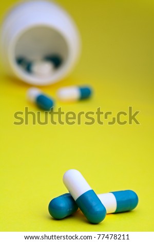 medicine prescription pills in a white bottle on a yellow background medication capsule prescription drugs tranquilizer or sleeping pill witch can lead to a drug addiction