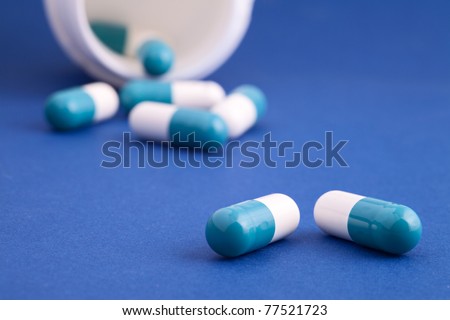 medicine prescription pills in a white bottle on a blue background medication capsule prescription drugs tranquilizer or sleeping pill  vitamin supplement vitamins or antibiotic pills