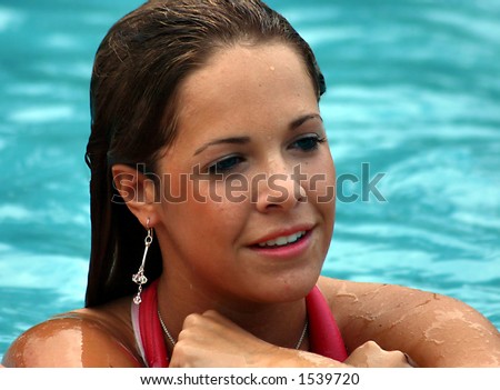 Beautiful All-American girl in the pool with wet face and hair