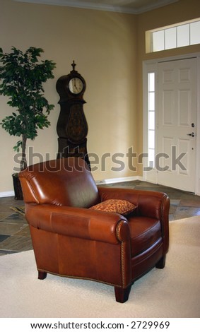 leather chair and grandfather clock in upscale home foyer