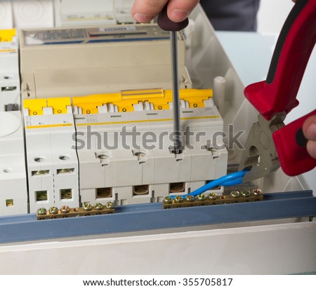 electrical appliance repairs. electrician fixing cable in domestic electrical plastic box