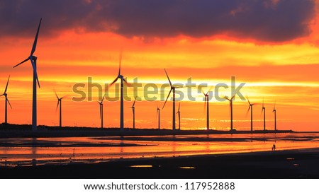 wind turbine array silhouettes at sea shore