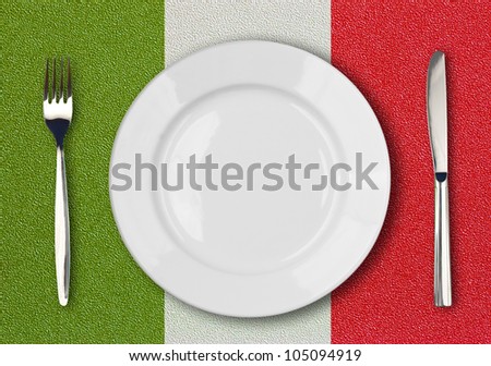 White plate, fork and knife top view on italian flag plastic table