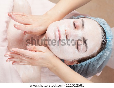 Beautiful woman with clear skin getting beauty treatment of her face at salon