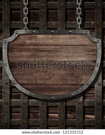 aged medieval shield signboard hanging on wooden gates