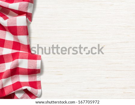 Red Folded Tablecloth Over Bleached Wooden Table