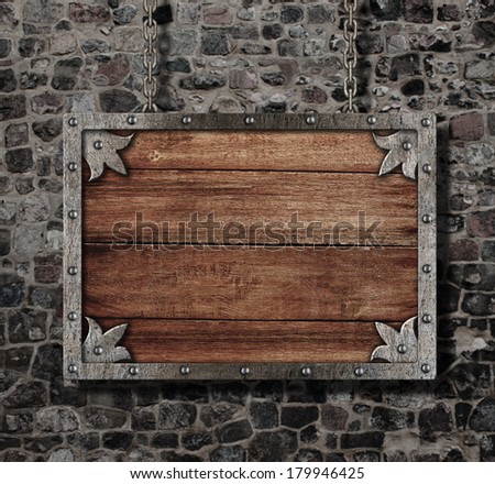 medieval old sign with chain on stone wall