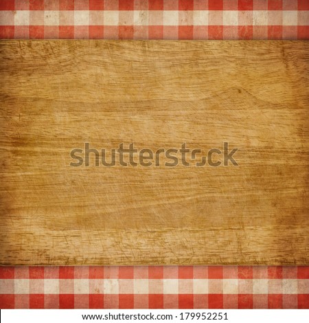 Cutting board over red grunge checked gingham picnic tablecloth background