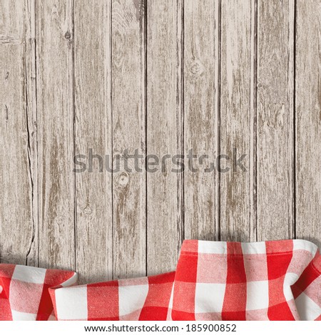 old wooden table with red picnic tablecloth background
