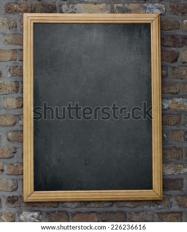 Aged green menu blackboard hanging on brick wall