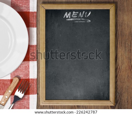 Menu chalkboard top view on table with dish, knife and fork
