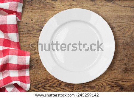 white empty dinner plate setting on wooden table with tablecloth