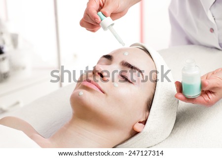 Serum facial treatment of young woman in spa salon