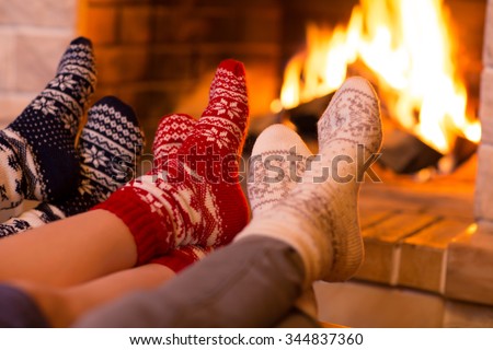 Feet in wool socks near fireplace in winter time