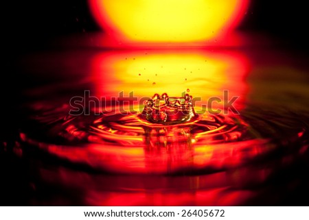 Splash of water drop in red-yellow palette on black background