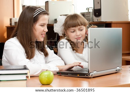 Two schoolgirls concentrated on their task with notebook