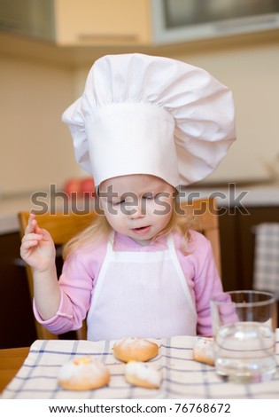 Little girl ready to eat cakes on kitchen