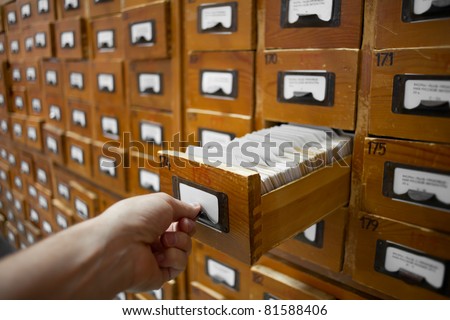 database concept. vintage cabinet. human hand opens library card or file catalog box.