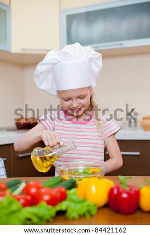Little girl with oil preparing healthy food on kitchen