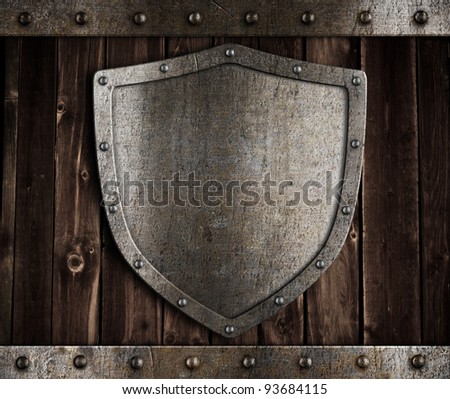 aged metal shield on wooden medieval gates
